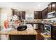 Kitchen featuring dark wood cabinets, granite countertops, stainless appliances, and wood floors at 3621 Guinevere Trce, Douglasville, GA 30135