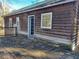 Rustic exterior view of home with a wooden deck, multiple windows, and a door leading to the outdoors at 4195 Turner Dr, Cumming, GA 30040