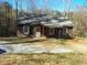 Charming one-story cabin featuring a cozy front porch and surrounded by a wooded landscape at 4195 Turner Dr, Cumming, GA 30040