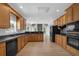 Spacious kitchen features wood cabinets, dark countertops, stainless steel appliances, and wood floors at 5755 Vinings Place Se Ct, Mableton, GA 30126