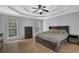 Bright bedroom with tray ceiling, hardwood floors, a large window and a stylish furniture set at 5755 Vinings Place Se Ct, Mableton, GA 30126