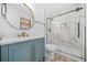 Stylish bathroom with marble shower, blue vanity, gold fixtures, and a round mirror at 897 Marie Sw Ln, Conyers, GA 30094