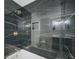 Luxurious bathroom with black marble tile, gold fixtures, and a shower-tub combination, exuding modern style at 897 Marie Sw Ln, Conyers, GA 30094