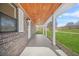 Inviting covered front porch with wood ceiling, brick accents, and stylish lighting at 897 Marie Sw Ln, Conyers, GA 30094
