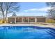 The backyard features a sparkling in ground pool and brick home with a covered patio at 897 Marie Sw Ln, Conyers, GA 30094