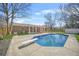 Backyard featuring a brick home, large in ground pool with diving board, mature trees and green grass at 897 Marie Sw Ln, Conyers, GA 30094