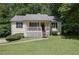 Charming single-story home featuring a front porch, well-maintained lawn, and mature trees providing shade and curb appeal at 213 Johnstons Dr, Dallas, GA 30157