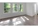 Sun-filled bedroom featuring luxury vinyl plank flooring and three large bright windows at 293 Quail Run, Roswell, GA 30076