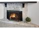 Close up view of a stone fireplace featuring a fireproof screen and hearth, with a potted plant beside it at 293 Quail Run, Roswell, GA 30076