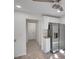 Bright kitchen provides stainless fridge, white cabinets, and opens to the hallway at 293 Quail Run, Roswell, GA 30076