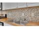 This kitchen includes butcher block countertops and neutral tile backsplash at 293 Quail Run, Roswell, GA 30076