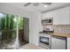 Modern kitchen with stainless appliances and sliding door to exterior deck, perfect for entertaining at 293 Quail Run, Roswell, GA 30076