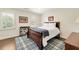 Comfortable bedroom features hardwood floors, natural light, and a charming plaid rug at 1018 Layfield Ct, Dunwoody, GA 30338