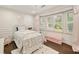Charming bedroom with a bay window, decorative molding, hardwood floors, and white iron bed frame at 1018 Layfield Ct, Dunwoody, GA 30338