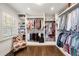 Walk-in closet with custom shelving, hanging rods, natural light, and a stylish chair at 1018 Layfield Ct, Dunwoody, GA 30338