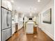 Spacious kitchen featuring modern appliances, white cabinets, island with stools, and hardwood floors at 1018 Layfield Ct, Dunwoody, GA 30338