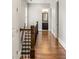 Hardwood hallway with staircase with dark wood banister leading to a bathroom at 1202 Hardee Ne St, Atlanta, GA 30307