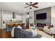 Open-concept living room featuring a fireplace, a ceiling fan, and a modern kitchen island with barstool seating at 1202 Hardee Ne St, Atlanta, GA 30307