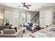 Open-concept living room with contemporary furniture, large windows, and stairs to the upper level at 1202 Hardee Ne St, Atlanta, GA 30307