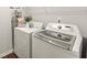 Bright laundry room features a modern washer and dryer set, ironing board, and stylish decor at 139 Treeline Trl, Canton, GA 30115