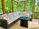 Cozy screened porch with a sectional sofa and fire table overlooking a lush, green landscape at 139 Treeline Trl, Canton, GA 30115