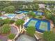 Aerial view of community tennis courts and swimming pools surrounded by mature trees and landscaping at 5650 Buckleigh Pointe, Suwanee, GA 30024