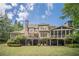 Expansive backyard featuring a stone fireplace, screened porch, and a lush green lawn at 5650 Buckleigh Pointe, Suwanee, GA 30024