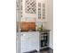 Charming bar area with custom cabinetry, built-in wine rack, and a sleek beverage refrigerator at 5650 Buckleigh Pointe, Suwanee, GA 30024