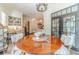 Bright dining area featuring wood table, chandelier, and adjacent workspace with custom built-in bookshelves at 5650 Buckleigh Pointe, Suwanee, GA 30024