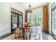 Bright dining room featuring a round wooden table and large windows with draperies at 5650 Buckleigh Pointe, Suwanee, GA 30024