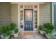 Charming front door with decorative glass, sidelights, and potted plants on a stone porch at 5650 Buckleigh Pointe, Suwanee, GA 30024