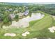 Aerial view of a well-manicured golf course with a lake, lush green fairways, and mature trees at 5650 Buckleigh Pointe, Suwanee, GA 30024