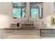 Close-up of a stainless sink and marble backsplash in a kitchen with natural light at 5650 Buckleigh Pointe, Suwanee, GA 30024