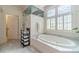 Elegant main bathroom boasts soaking tub, walk in shower, and modern fixtures at 5650 Buckleigh Pointe, Suwanee, GA 30024