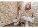 Charming powder room with decorative wallpaper, pedestal sink, and elegant fixtures at 5650 Buckleigh Pointe, Suwanee, GA 30024