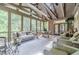 Spacious screened porch with vaulted ceilings, stone fireplace, and comfortable seating for relaxing and entertaining at 5650 Buckleigh Pointe, Suwanee, GA 30024