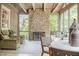 Relaxing screened porch features a stone fireplace and comfortable seating for enjoying the outdoors at 5650 Buckleigh Pointe, Suwanee, GA 30024