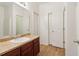 Bathroom featuring wood floors, a dark wood cabinet with light stone countertop, and a large mirror at 1065 City Park Dr, Mcdonough, GA 30252