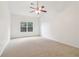 Bright, empty bedroom with vaulted ceiling, ceiling fan, carpeted floor, and a large window at 1065 City Park Dr, Mcdonough, GA 30252