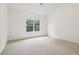 Bedroom with neutral carpet, white walls, large window, and electrical outlets at 1065 City Park Dr, Mcdonough, GA 30252
