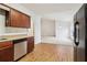 Open kitchen with wood cabinets, laminate countertops, stainless steel dishwasher, and view into the dining area at 1065 City Park Dr, Mcdonough, GA 30252