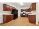 Well-lit kitchen features wooden cabinets, laminate countertops, wood-look flooring, and a modern black refrigerator at 1065 City Park Dr, Mcdonough, GA 30252