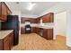 Bright kitchen with dark wood cabinets, stainless steel dishwasher, modern appliances, and wood-look flooring at 1065 City Park Dr, Mcdonough, GA 30252