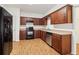 Well-lit kitchen featuring modern appliances, wooden cabinets, laminate countertops, and wood-look flooring at 1065 City Park Dr, Mcdonough, GA 30252