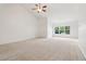Expansive open living area with neutral carpet, a ceiling fan, and natural light, perfect for relaxation and entertaining at 1065 City Park Dr, Mcdonough, GA 30252
