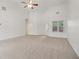 Spacious living room with neutral carpet, high ceilings, a ceiling fan, and ample natural light from the large window at 1065 City Park Dr, Mcdonough, GA 30252