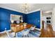 Dining room with blue accent walls, modern light fixture, table with seating, and hardwood floors at 1229 Concord Se Rd, Smyrna, GA 30080