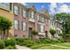 Row of brick townhomes with dark shutters and landscaped yards on a sunny day with blue sky at 1229 Concord Se Rd, Smyrna, GA 30080