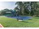 A well-equipped playground area with swings and play structures surrounded by mature trees and grass at 1229 Concord Se Rd, Smyrna, GA 30080