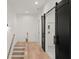 Hallway with hardwood floors, modern railing, and sliding barn doors to bathroom at 2327 Mason Dr # D23, Atlanta, GA 30316